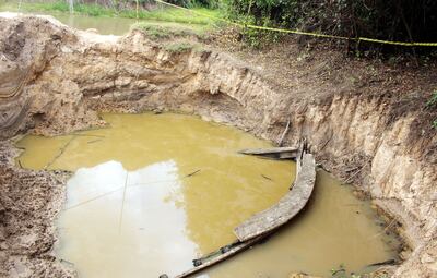 Parte de la embarcación de madera de la época de la Guerra contra la Triple Alianza hallada el pasado día 3 a orillas del río Yhaguy, cuyo cauce principal se ve parcialmente en el fondo.