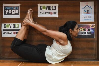 La instructora de yoga Pratibha Agarwal hace la postura del arco, durante el confinamiento en su casa, por la pandemia de coronavirus.