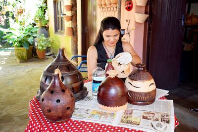Grissel Sánchez pinta las lámparas que fueron moldeadas por su padre, don Toribio, en su taller de artesanía.