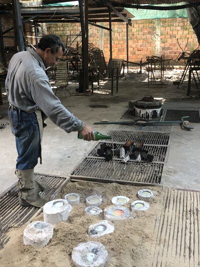Erico Torales bendiciendo con cerveza las piezas fundidas de Adriana González Brun, tal como siempre ha sido la costumbre en el taller de Gustavo Beckelmann.