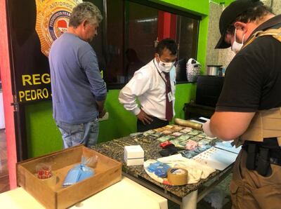 Osvaldo Martínez Fretes (I) observa atentamente el recuento de las evidencias encontradas en su residencia.