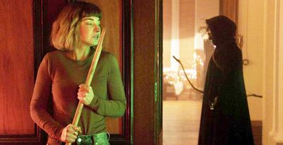 Imogen Poots se esconde del extraño asesino encapuchado y enmascarado que ha entrado en la residencia universitaria para matar a todas en la película “Negra Navidad”.