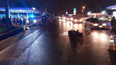 El cuerpo de la víctima yace tendido inerte sobre el pavimento. El conductor de la motocicleta también sufrió lesiones graves.