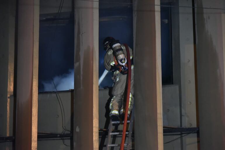 Un bombero aplaca el incendio en General Díaz y 14 de Mayo.