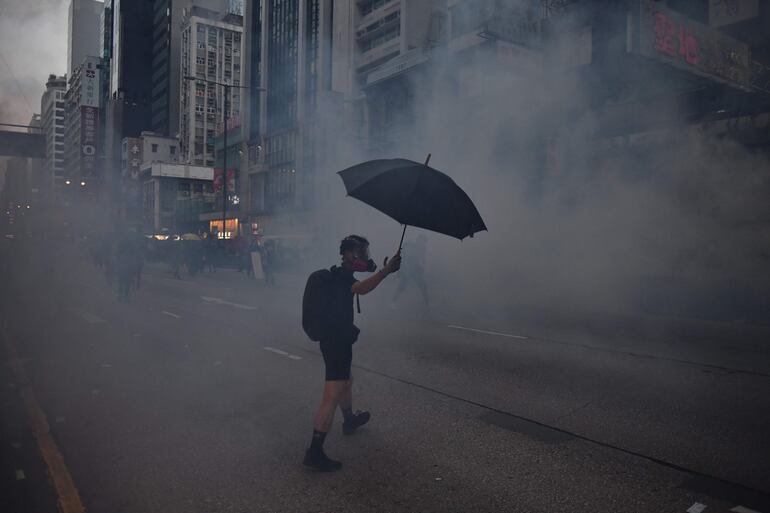 Un manifestante con máscara de gas se enfrenta a la policía en Hong Kong, este domingo.