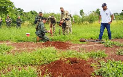 Explosivistas de la Senad y la FTC preparan una de las cargas explosivas enterradas en la pista clandestina destruida ayer en la colonia Cerro Cora’i de Pedro Juan Caballero.