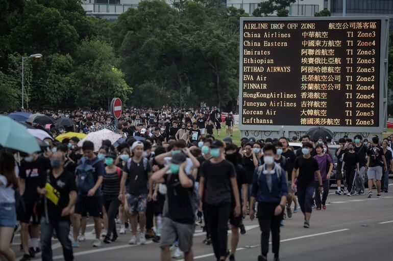 Los manifestantes caminan por una de las autopistas cercanas al aeropuerto.