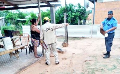 Un técnico del Senepa explica a una pobladora de Filadelfia cómo evitar los criaderos de mosquitos.