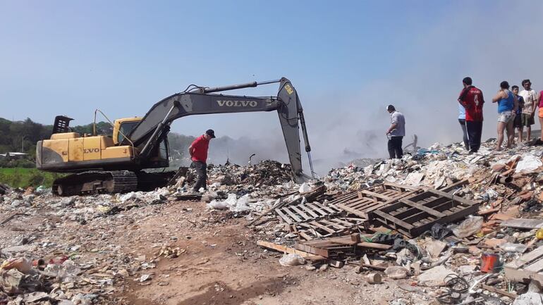 Una retroexcavadora remueve las basuras para ir sofocando los focos que quedaron bajo las pilas de desechos.