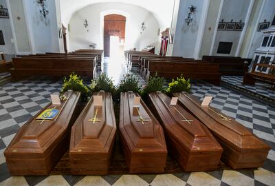 Ataúdes de personas que murieron por el coronavirus, dispuestos en el piso de la iglesia de Serina, cerca de Bérgamo, al norte de Italia.