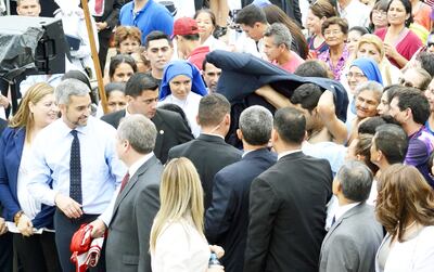 El presidente Mario Abdo ya tiene en sus manos la remera que le dio un joven, mientras este se pone el saco del mandatario.