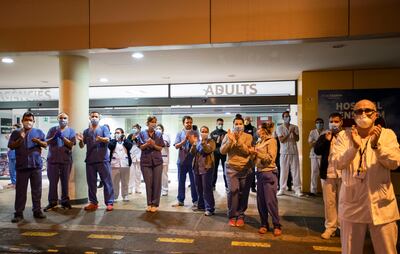 Trabajadores de la salud en España aplauden en retorno a aquellos que los felicitan y les dan apoyo por su trabajo. Hospital Son Espases, Mallorca.