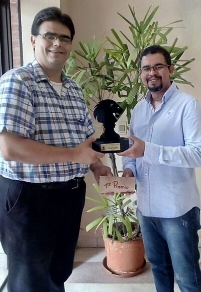 El GM Neuris Delgado (d) recibe el trofeo de campeón Absoluto 2019 de ajedrez de manos del titular de Feparaj, Ronald Zarza.