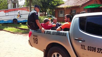 Los detenidos son escoltados por un agente de la Policía Nacional, este lunes en Pedro Juan Caballero.