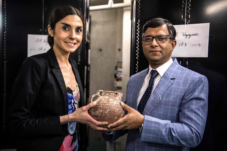 La oficial de la aduana francesa Anne-Sophie Vitoux entrega un objeto antiguo a un oficial de la embajada de Pakistán en Francia, en el aeropuerto de Roissy. 