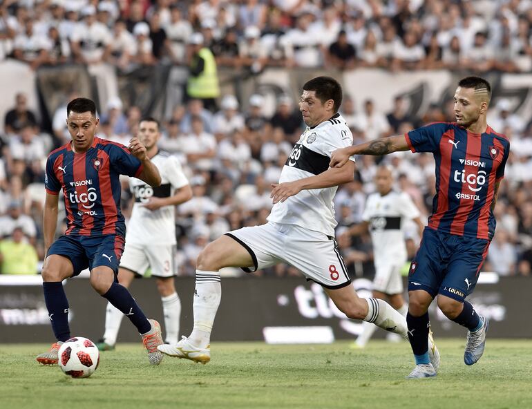 Rodrigo Rojas con la pelota en medio de los azulgranas, Ángel Cardozo Lucena y Josué Colmán, el clásico de la sexta fecha del torneo Apertura de este año: 1-1.
