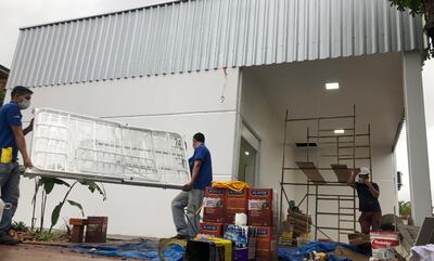 Obreros de las  contratistas trasladan una de las camas del   nuevo pabellón de aislamiento en el hospital regional.