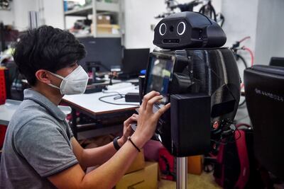 Un estudiante de ingeniería configura un robot médico modificado para inspeccionar y observar a pacientes con coronavirus en Bangkok.