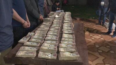 Sospechosos detenidos con los fajos de bolívares.