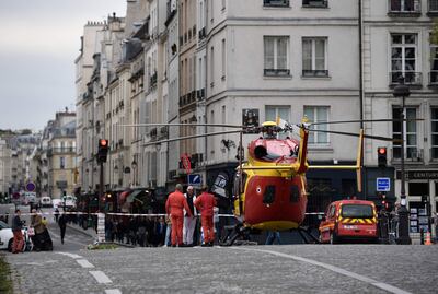 Personal de emergencia próximo a un helicóptero estacionado en el Puente Marie, cerca del Cuartel de Policía de París.