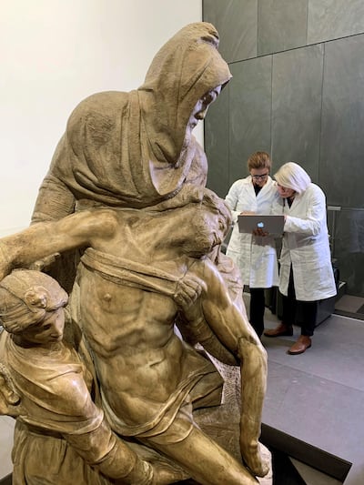Paola y Emanuela trabajan junto a la escultura de la Piedad de Miguel Ángel en el Museo de la Obra de la Catedral en Florencia, Italia.