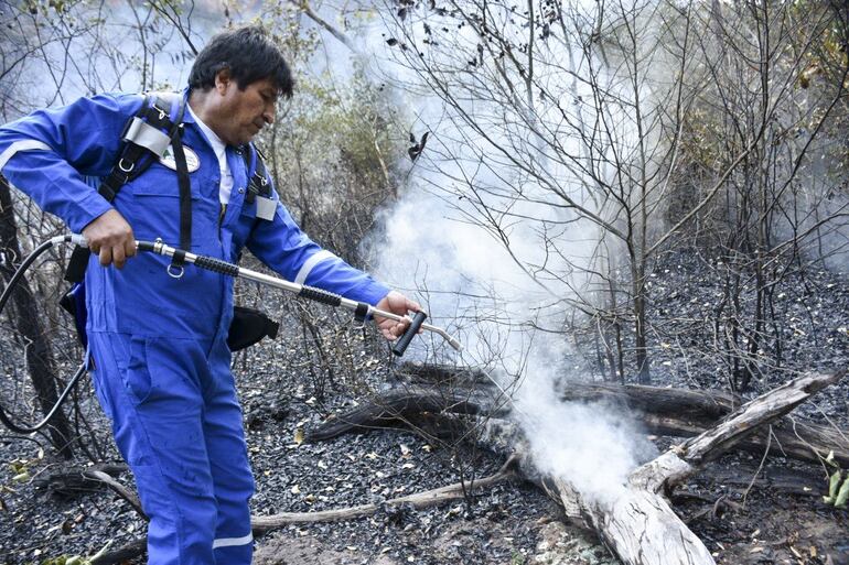Evo Morales asperja agua en un incendio en la comunidad de Santa Rosa, cerca de Robore, en Bolivia.