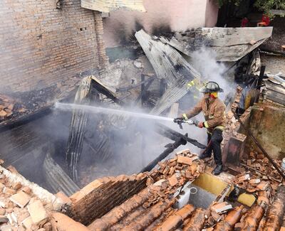 Desde arriba, un voluntario extingue los últimos focos de fuego que quedaban en el sitio.