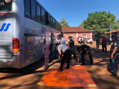 Los agentes retiran os panes de marihuana del interior del bus.