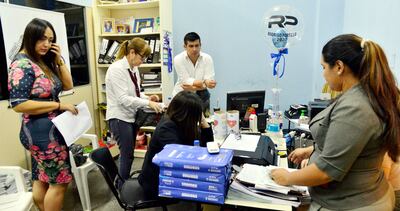 La fiscala Laura Ávalos (i.), verifica documentos  de la Comuna lambareña, durante el allanamiento.