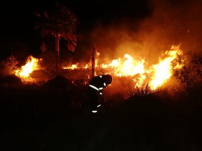 Un bombero voluntario se acerca a las llamas del incendio forestal que ocurrió anoche en Luque