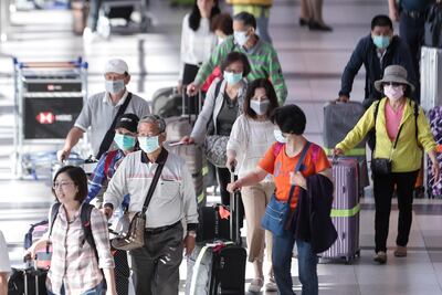 Pasajeros usan cubrebocas para protegerse del coronavirus mientras transitan por el Aeropuerto Internacional de Ezeiza hoy viernes en Buenos Aires.