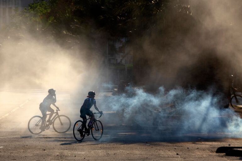 Manifestantes en bicicleta chocan con las fuerzas de seguridad durante una de las protestas con el gobierno de Piñera.