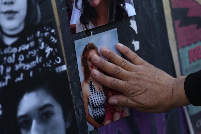 Mujeres colocan una ofrenda para todas las víctimas de feminicidio en la columna del Ángel de la Independencia en Ciudad de México (México).