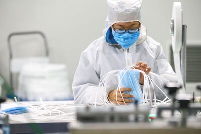 A worker produces protective face masks at a factory in Qingdao in China's eastern Shandong province, on February 6, 2020, to support the supply of medical materials during a virus outbreak that originated from Hubei's provincial capital city of Wuhan. - The number of confirmed infections in China's coronavirus outbreak has reached 28,018 nationwide with 3,694 new cases reported, the National Health Commission said on February 6. (Photo by STR / AFP) / China OUT