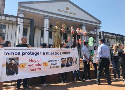 Activistas pusieron muñecas con bocas tapadas y manchas rojas por la reja del Poder Judicial de Ciudad del Este, como protesta.