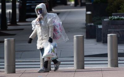 Una persona con mascarilla camina frente a la sede del Fondo Monetario Internacional en Washington.
