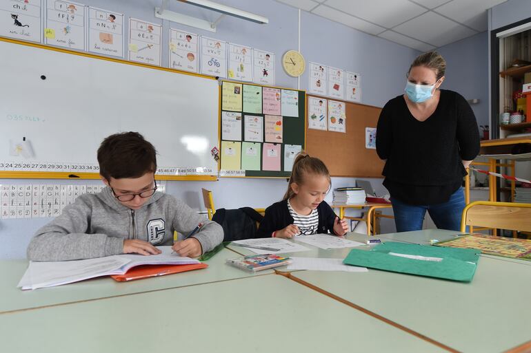 Una docente con mascarilla da clases en la escuela Alix de Bretagne, en la localidad francesa de Saint-Aubin-du-Cormier.