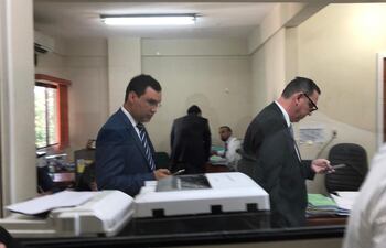 El senador imputado Javier Zacarías Irún (der.) ingresa al juzgado de Cinthia Garcete Urunaga, mientras revisa su teléfono celular. Ingresó por el estacionamiento privado del Tribunal, con la anuencia de los funcionarios para evitar a escrachadores.