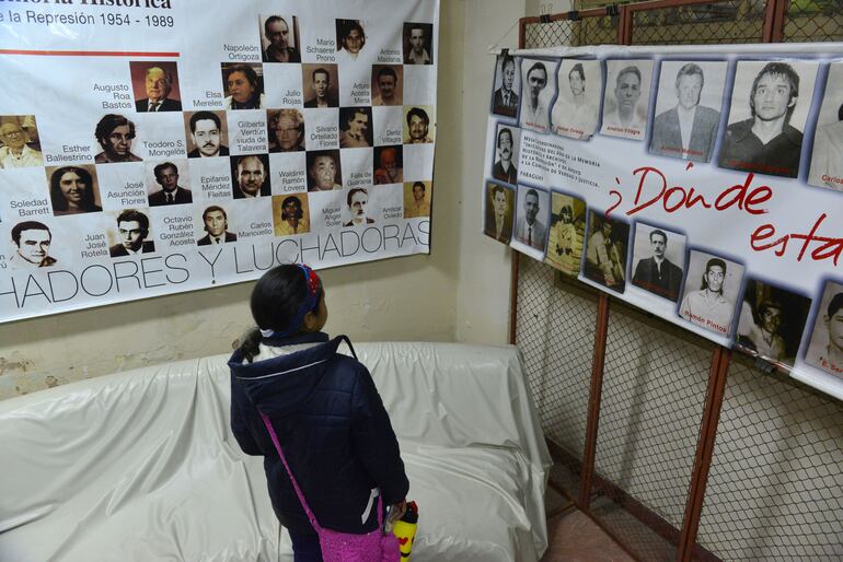 Una niña, que ya forma parte de la generación que creció en libertad, observa una de las principales consecuencias del régimen violento, las muertes y desapariciones.