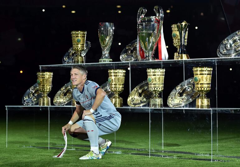 Schweinsteiger posando con los títulos que ganó en el Bayern Munich.
