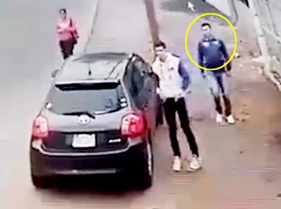 El exconvicto Marco Antonio Silva (en círculo), cuando estaba a punto de atracar con su cómplice un vehículo estacionado.