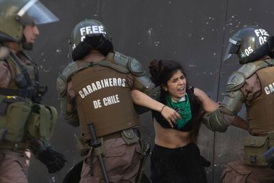 Policía antidisturbios apresa a una manifestante en Santiago de Chile.