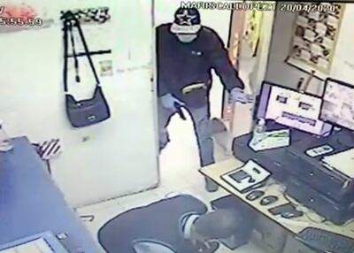 El empleado de la sala de seguridad, sorprendido por uno de los asaltantes, que finalmente se llevó un bolso de mujer que estaba colgado ahí.