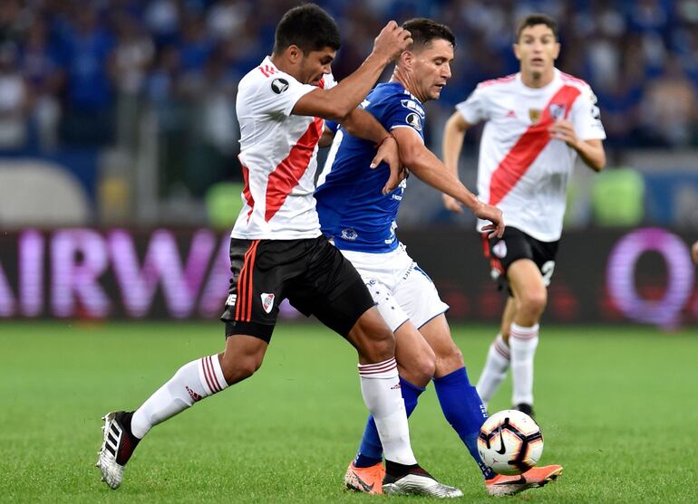 Robert Rojas (i), de River Plate, disputa el balón con Thiago Neves, de Cruzeiro, durante el partido disputado anoche en Belo Horizonte.
