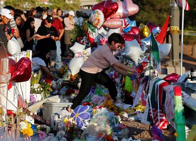 Una mujer coloca un objeto en un memorial a las víctimas de la matanza en El Paso, Texas.