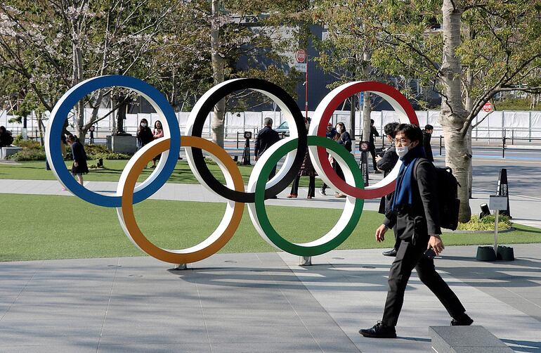 Una persona con mascarilla camina por las cercanías del Estadio  Olímpico de Tokio. Los Juegos Olímpicos de 2020 buscan fechas para celebrarse en 2021.