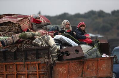 Civiles sirios desplazados llegan a la ciudad de Idlib en un camión.