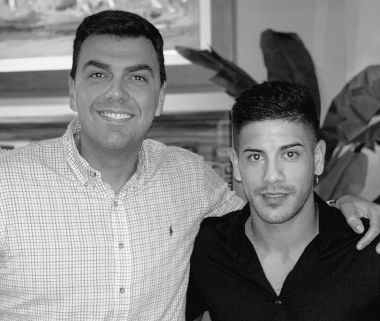 En blanco y negro, Marco Trovato y el jugador Jorge Recalde.