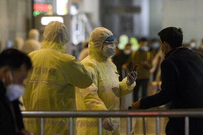 Trabajadores médicos realizan controles en una estación de trenes en Shanghai, China.