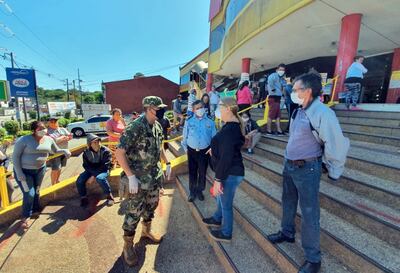 La fiscala Teresa Sosa conversa con un militar en la entrada del local comercial Luisito, sobre la avenida Félix Bogado.